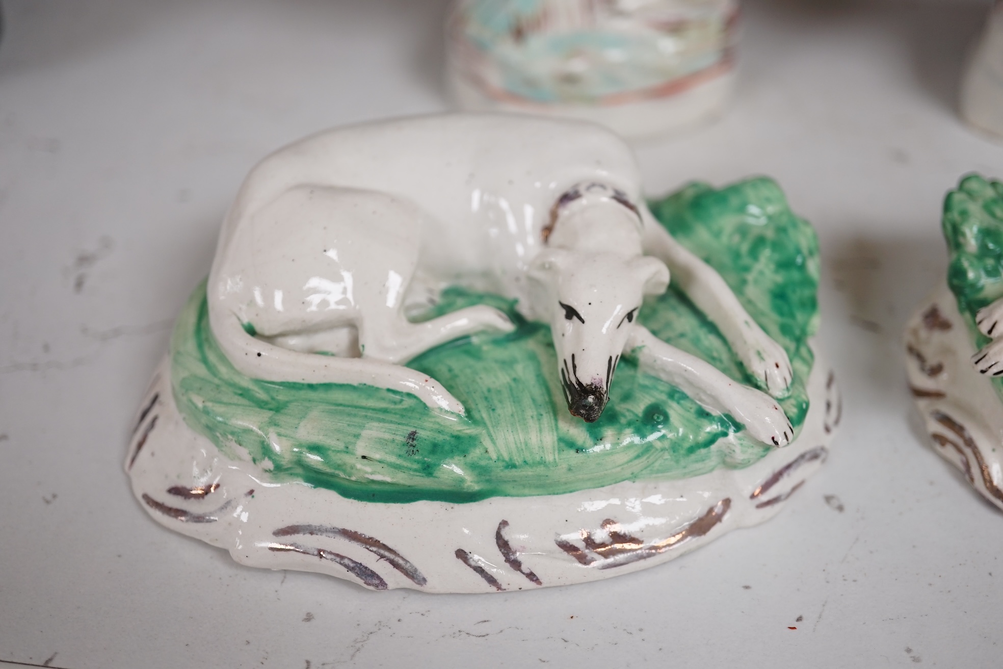 A pair of mid 19th century Staffordshire figures of recumbent greyhounds, 11 cm wide and a pair of similar groups of rabbits, 9.5cm high (4). Condition – fair to good